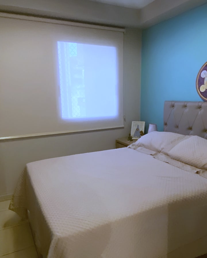 Quarto com persiana rolô filtrando a luz da janela, em Goiânia