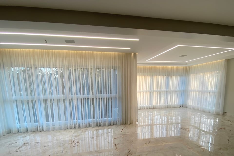 Sala com piso de mármore e cortina de voil sob medida, em Goiânia