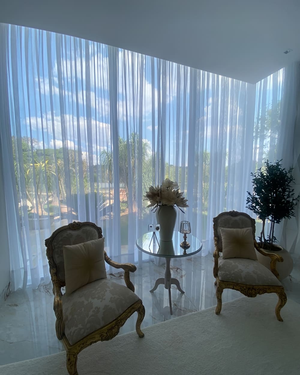 Cortina de voil com vista para jardim e poltronas clássicas, em Goiânia